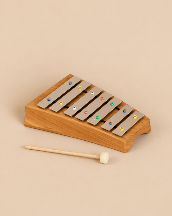 Choroi Carillon Pentatonic Glockenspiel - 7 tones featuring metal bars mounted on a curved cherry wood base, accompanied by a single mallet.