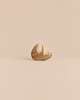 A small, sustainable Handmade Holzwald Small Sloth wooden figurine hanging from a branch.