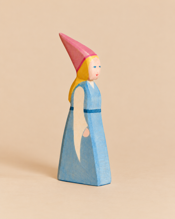 Ostheimer Daughter of the Castle, a hand-painted wooden figurine of a girl wearing a long blue dress and a tall pink pointed hat.