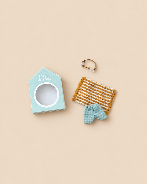 The Maileg Beach Bundle for Big Brother includes a small cardboard beach hut box, a striped towel, plaid shorts, and a tiny gold-tone wire ring.