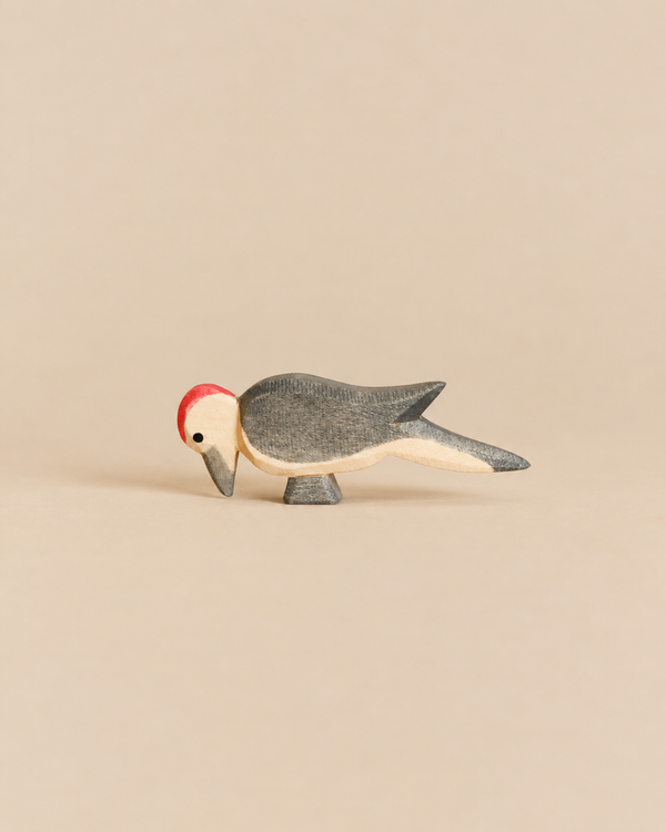 Handcrafted Ostheimer Woodpecker toy with a red crest, grey body, and light underside, perfect for imaginative play.