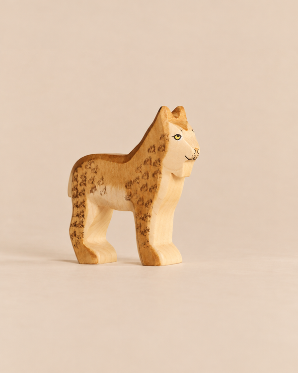 Handmade Holzwald Lynx, a hand-carved wooden figurine and sustainable toy with painted spots and yellow eyes.