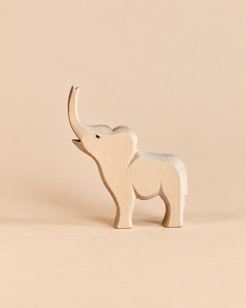 An Ostheimer Small Elephant - Trumpeting, a handcrafted wooden figurine with its trunk raised, designed for imaginative play.