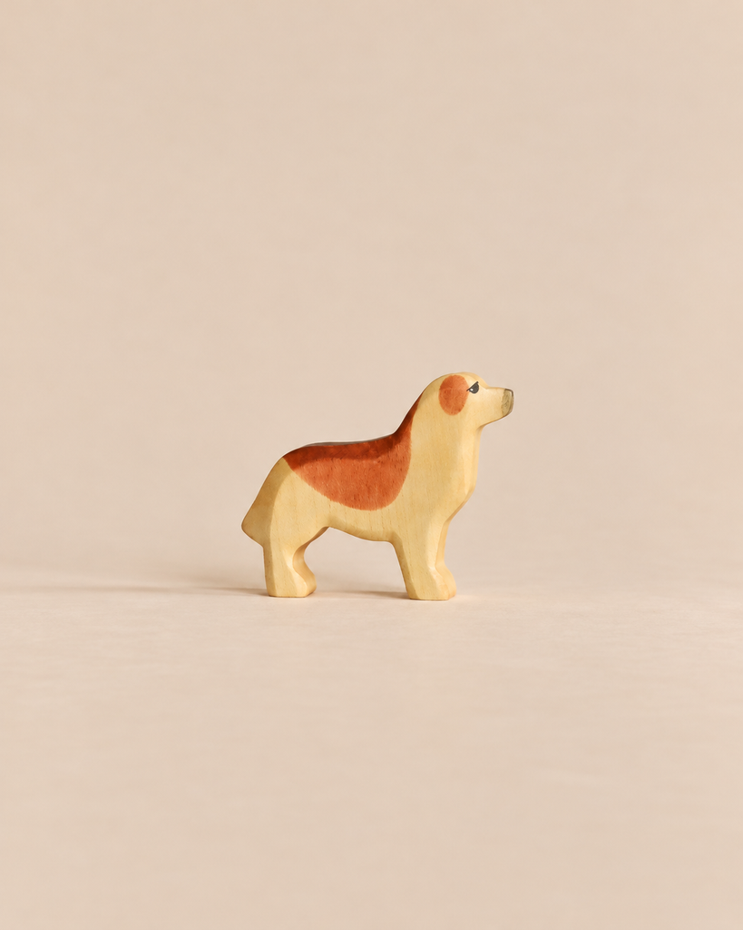 A small wooden Handmade Holzwald Dog - Golden Retriever figurine with light tan and brown markings standing in profile, representative of sustainable toys.