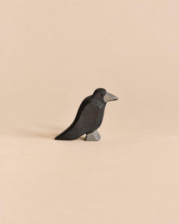 Handcrafted Ostheimer Bird - Raven wooden figurine shown in profile.
