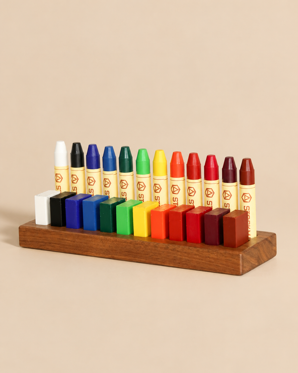 A set of multicolored Stockmar Crayon Set With Wooden Organizer Tray wax crayons and matching crayon blocks arranged in a wooden tray organizer.