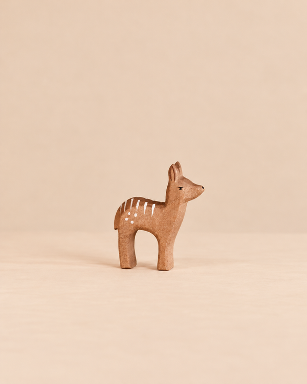 An Ostheimer Deer - Red Fawn, Standing, a small, handcrafted wooden toy in a standing position with painted white spots on its back for imaginative play.