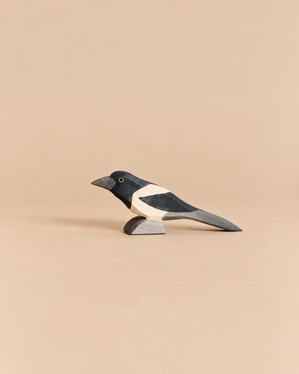 An Ostheimer Bird - Magpie, a handcrafted wooden figurine with black and white markings, perfect for imaginative play.