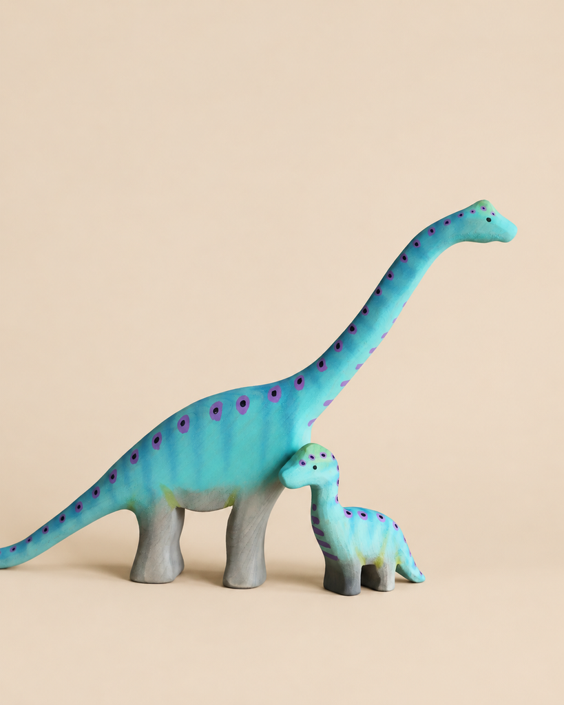 Bumbu Handmade Wooden Brontosaurus Dinosaur Set featuring two handcrafted wooden figures, one large and one small, both blue and decorated with purple spots.