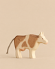 Handmade Holzwald Cow wooden toy with brown patches and a rope tail.