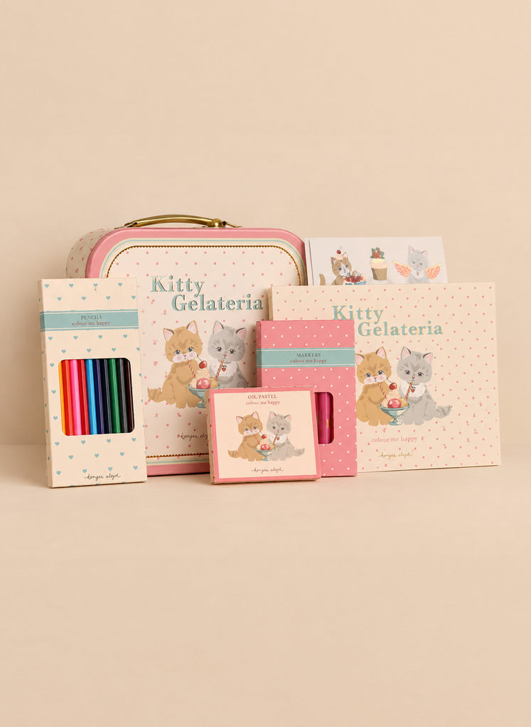 A Konges Sloejd Little Artist Set - Kitty Friends featuring a metal tin, coloring pencils, markers, oil pastels, and a sketchbook, all decorated with illustrations of kittens eating ice cream.