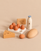Sabo Concept Handmade Wooden Country Dairy Set featuring a carton with five eggs, a block of butter, a milk bottle, a wedge of cheese, and an additional egg.