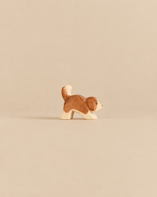 Handcrafted Ostheimer Dog - Saint Bernhard, Small - Head Down wooden figurine of a brown and white dog with its head bowed.