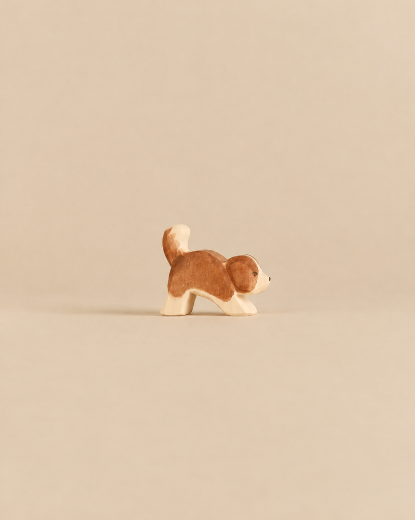 Handcrafted Ostheimer Dog - Saint Bernhard, Small - Head Down wooden figurine of a brown and white dog with its head bowed.