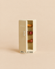 Miniature cream-colored Maileg Kitchen Set refrigerator with the door ajar, containing three small food items on the shelves.