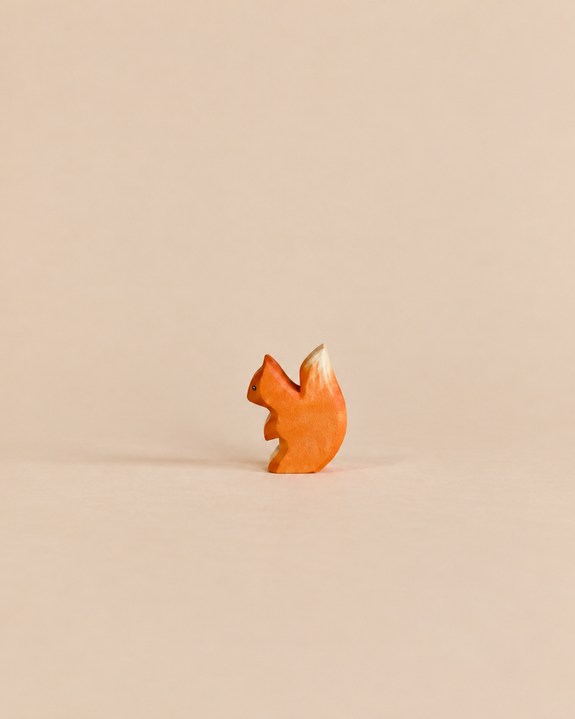 Handmade Holzwald Small Squirrel figurine featuring orange fur and a cream-colored tail tip, crafted as a sustainable wooden toy.