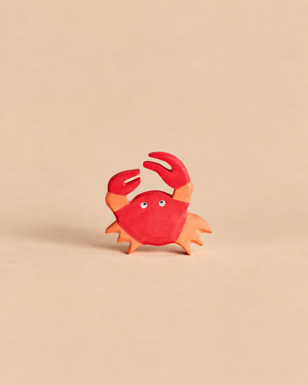 Handcrafted Holztiger Crab wooden toy painted in shades of red and orange.