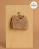 The Minikane Doll Clothing | Babies – Terry Sleeveless Vest in beige is a small, sleeveless vest with two buttons, displayed on a hanger against a tan background. Fits Minikane 11'' dolls—perfect for baby doll outfits.