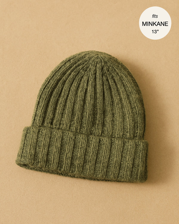The Minikane Doll Accessories Barry Knit Beanie in green is shown on a tan background with a white circle that reads "fits MINIKANE 13”".
