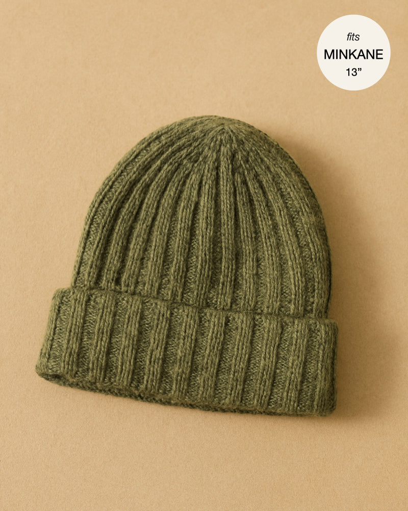 The Minikane Doll Accessories Barry Knit Beanie in green is shown on a tan background with a white circle that reads "fits MINIKANE 13”".
