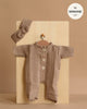The Minikane 11" Doll Clothing | Lili Jumpsuit & Headband in Cotton Gauze - Mocha is shown on a wooden hanger against a light wood panel, featuring white buttons and a matching knotted headband. Made in France.
