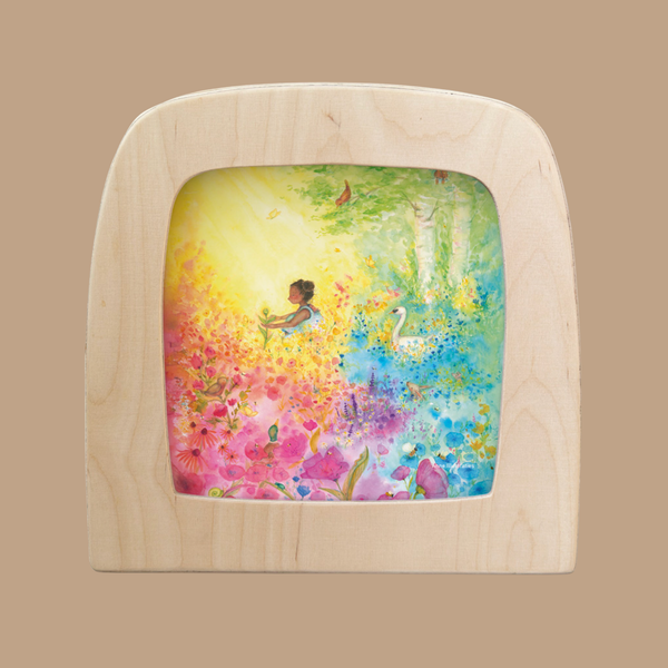 The "Silhouette Only - Into Bloom Silhouette for Toverlux Lamp" features a whimsical scene of a young girl among vibrant flowers with a swan, crafted by Anne Illustraties to create a dreamy, magical atmosphere when displayed in your lamp.