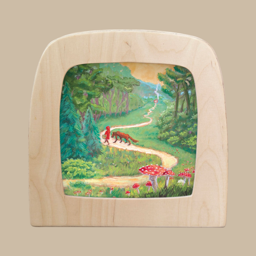 The Silhouette Only - Red Riding Hood for Toverlux Lamp features a winding yellow path through a green forest with trees, red mushrooms, Red Riding Hood, and a wolf beneath a partly cloudy sky—perfect for decorative display.