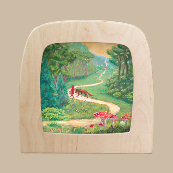The Silhouette Only - Red Riding Hood for Toverlux Lamp features a winding yellow path through a green forest with trees, red mushrooms, Red Riding Hood, and a wolf beneath a partly cloudy sky—perfect for decorative display.