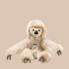 The Steiff Miguel Baby Dangling Sloth Plush Toy, 13 inches, features light brown premium plush fur, long arms, dark claw-like feet, a friendly face, and a small "Steiff" tag on its chest. It is shown sitting against a plain beige background.