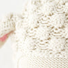 Close-up of Cuddle + Kind Benjamin the Lamb, featuring cream-colored, textured, hand-knit 100% cotton fabric with a hint of soft pink. Handmade in Peru.