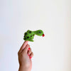 A hand with red-painted nails holds up the Snake Finger Puppet, featuring black spots and a red tongue, perfect for creative storytelling and imaginative play against a plain white background.