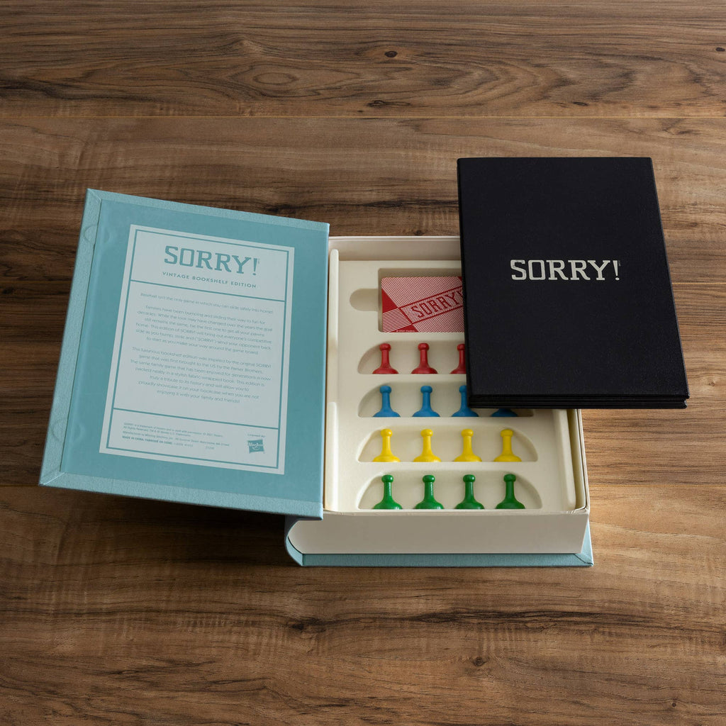An open Sorry! Vintage Bookshelf Edition box reveals a classic game board with colorful pieces, cards, instructions, and the collectible bookshelf edition insert displayed on a wooden surface.