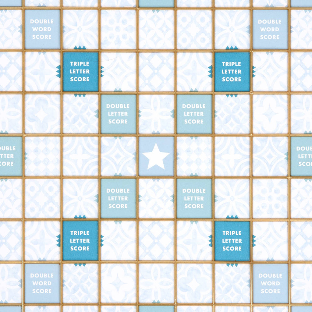 A Scrabble Bianco Edition game board with a wood frame, featuring a grid of white and light blue patterned squares, highlighted spaces for double word, triple letter, and double letter scores, and a center star.