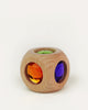 A Bauspiel Magic Cube, 1-Piece, featuring a wooden frame with circular openings on its faces containing faceted, colorful glass gems.