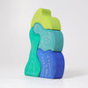 Grimm's Casa Aqua Building Blocks feature stacked organic shapes in green, teal, light blue, and dark blue with white line drawings and abstract patterns on a plain white background—ideal for imaginative play.
