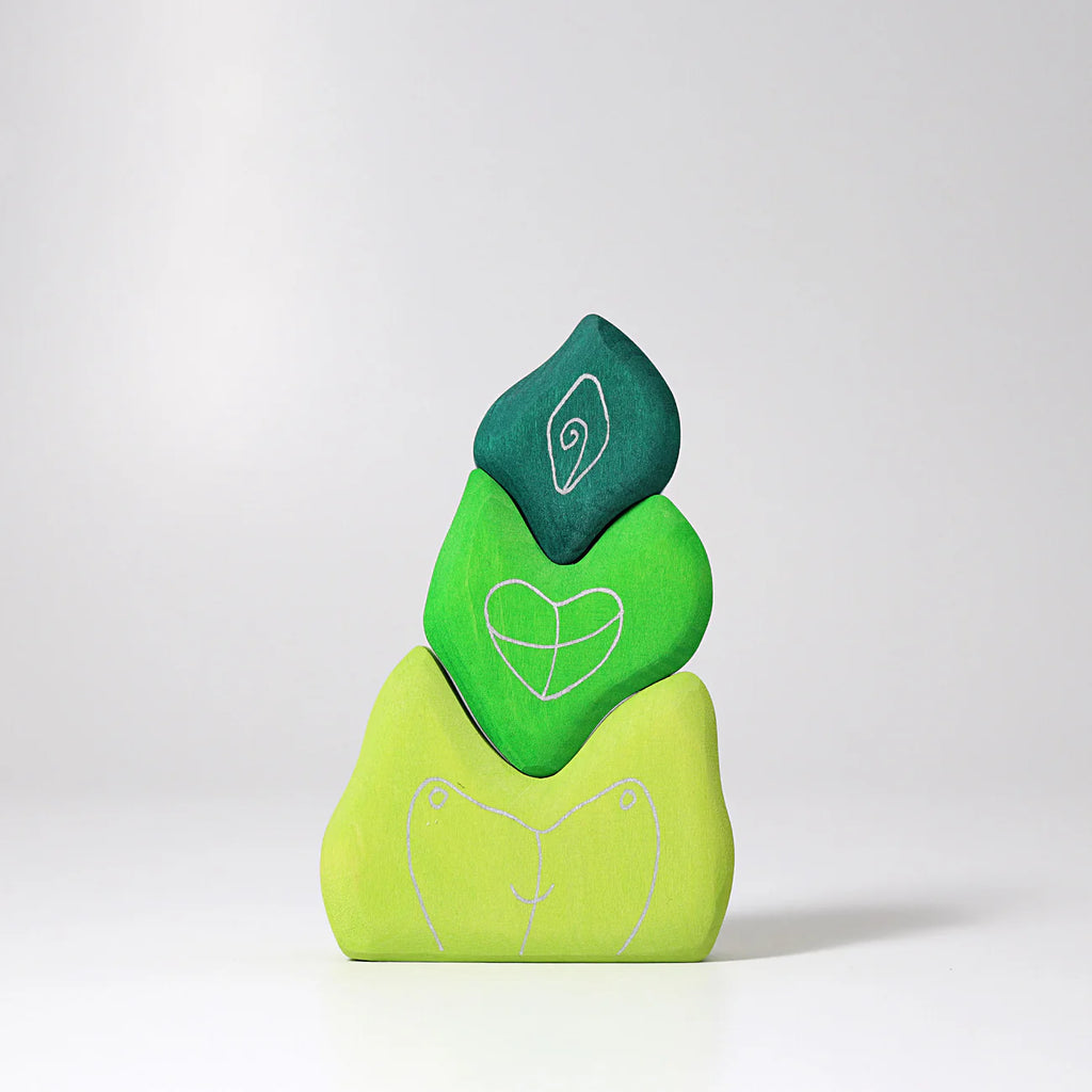 Three green Grimm's Tower Leaves Building Blocks made of handpainted lime wood are stacked, each with white line drawings: two birds on the bottom, a heart in the middle, and a spiral on top.