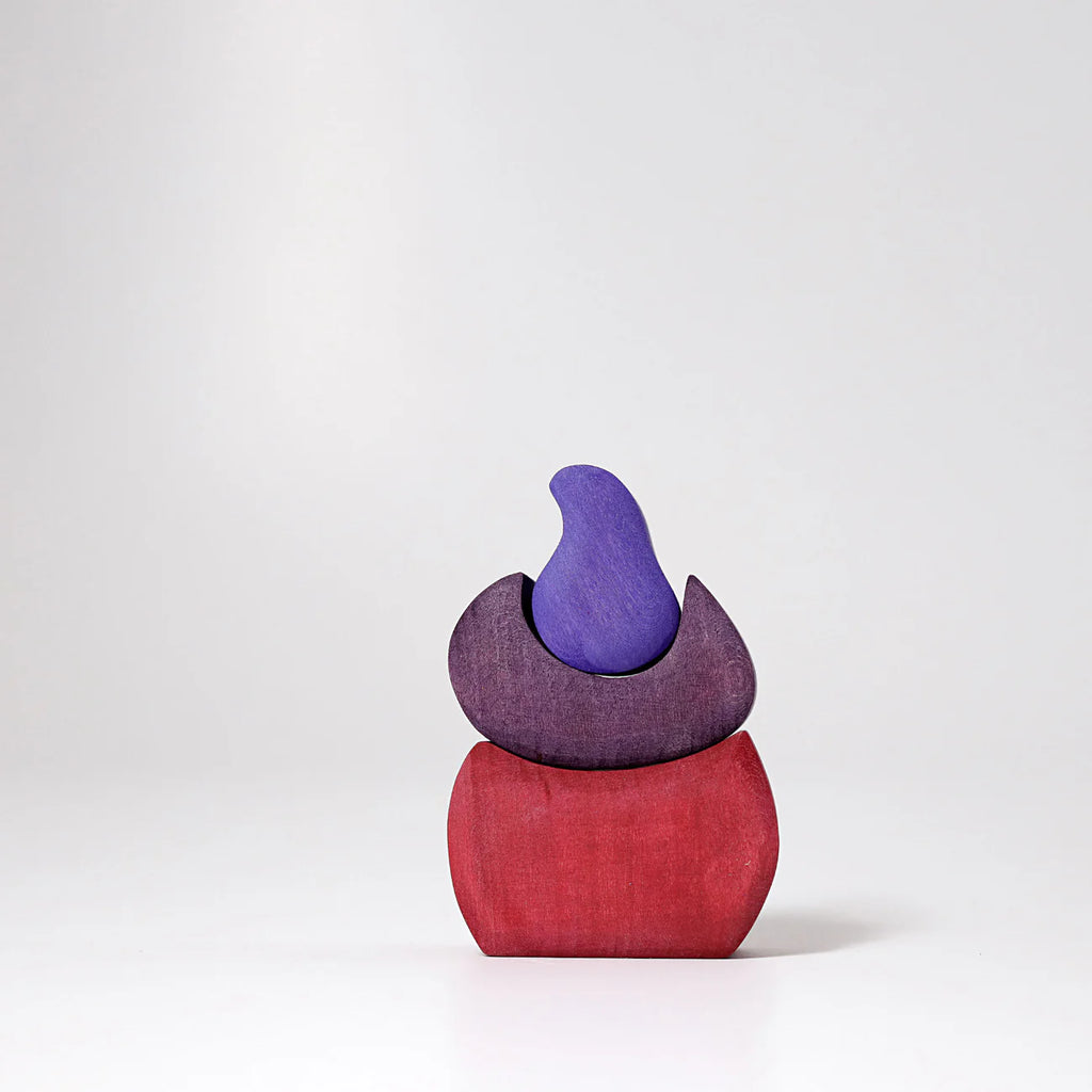 Grimm's Small Bakery Building Blocks, shaped in minimalist wood with a red base and purple top pieces, inspire imaginative play and are displayed on a plain light gray background.