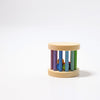 A Mini Rolling Wheel lies on a plain white surface, featuring a cylindrical shape with multicolored vertical bars and small colorful balls enclosed inside. The top and bottom are circular wooden caps, and within, tiny wooden beads create sound as they move around like a colorful wheel.