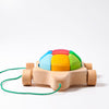 A Grimm's Rainbow Turtle Pull-Toy and Building Blocks featuring a small car with four wheels and a multicolored shell on top. Made from non-toxic materials, the car is attached to a green string for easy pulling. The shell has segments in blue, yellow, green, and red. Ideal for developing fine motor skills on a plain white background.