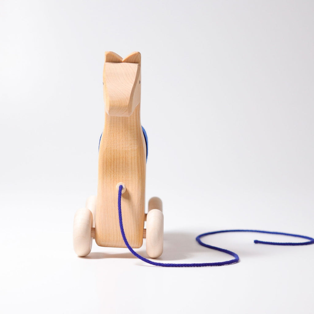 Grimm's Horse Holly is a wooden pull along horse toy on wheels, shown front-facing with a blue pull string against a plain white background—an adorable toddler toy.