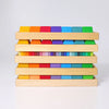 Grimm's Shapes and Colors Set features multicolored geometric building blocks in four wooden trays, each displaying a rainbow gradient from red to green—perfect for developing fine motor skills.