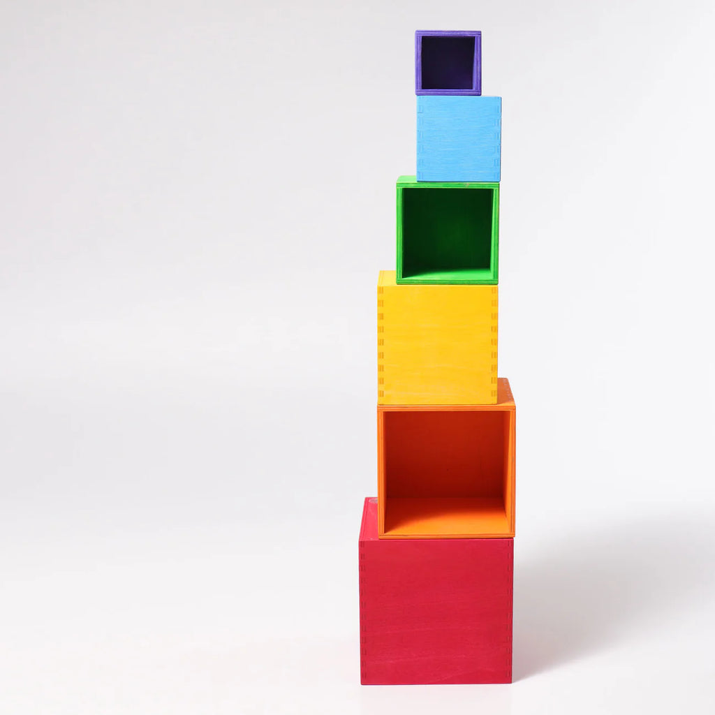 Grimm's Large Set of Boxes - Rainbow features five hollow wooden stacking boxes in red, orange, yellow, green, and blue—perfect for creative play and non-toxic fun. They nest by size against a plain white background.