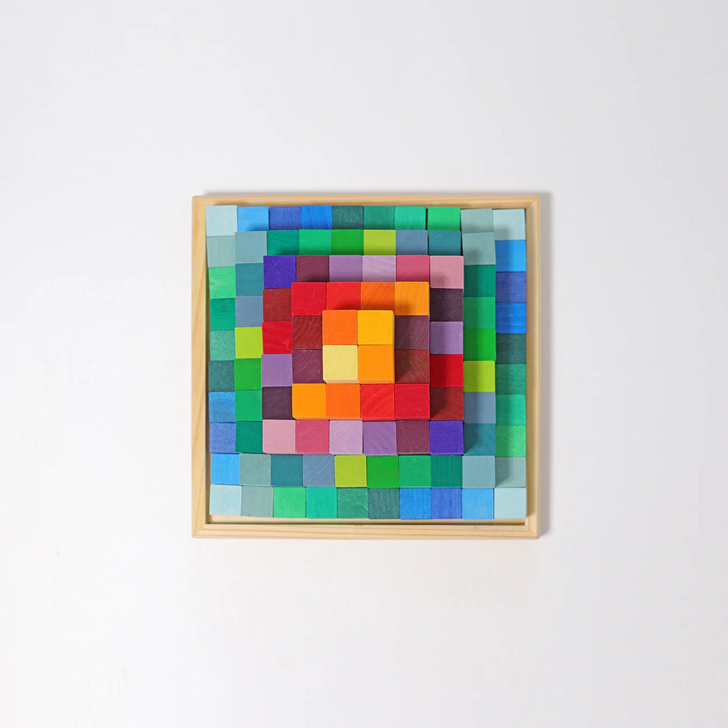 The Grimm's Stepped Pyramid Block Set - Small features colorful building blocks in a wooden frame, arranged in a grid that transitions from blue and green on the edges to red, orange, and yellow at the center for a vibrant mosaic effect.