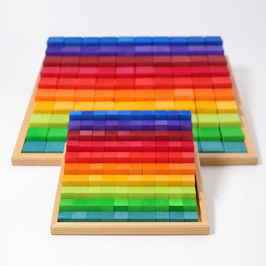Two wooden trays of Grimm’s Stepped Counting Blocks - Large filled with non-toxic building blocks arranged in rows by height, creating a stepped, gradient effect.