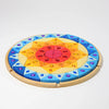 Grimm’s Sparkling Mandala Sun Creative Puzzle featuring circular wooden pieces arranged in a radiating pattern with colorful inlaid acrylic gemstones for fine motor skill development.