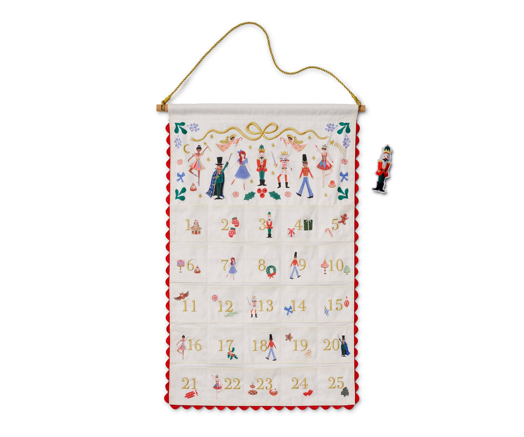 Nutcracker Embroidered Hanging Advent Calendar - Red featuring 25 numbered pockets, embroidered nutcracker-themed designs, and a matching Nutcracker figurine magnet.