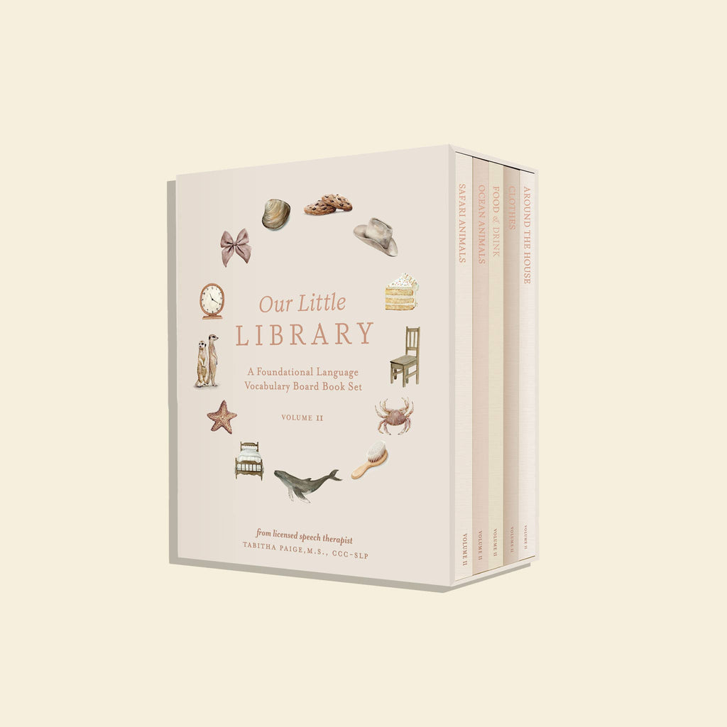 Our Little Library Vol. 2 is perfect for baby's vocabulary growth, featuring charming illustrations of a seashell, boot, and crab on a light background with three visible book spines in this delightful first words collection.