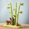 The Bumbu Handmade Wooden Red Panda Family with Bamboo Set features three handcrafted figures and tall bamboo stalks on a green base, making it perfect for Montessori learning and imaginative play on any wooden surface.