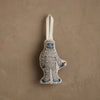 The Coral & Tusk Yeti with Candy Cane Ornament, featuring white fur, blue details, and a candy cane, hangs by a white loop—perfect as a charming Christmas decoration or whimsical gift.