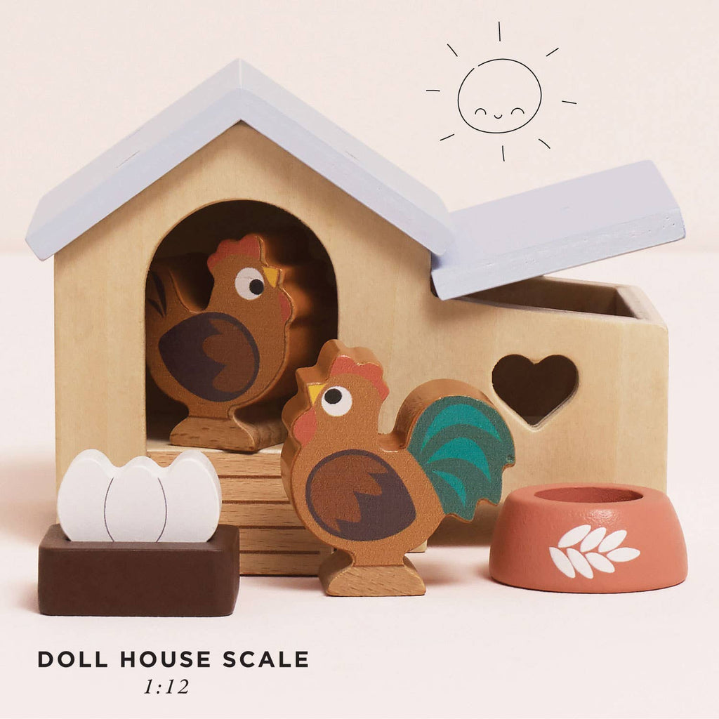 The Chicken Coop Playset is a delightful farmyard toy made from FSC-certified wood, featuring a coop with a heart window, hen, rooster, eggs, bowl, and a sun illustration.